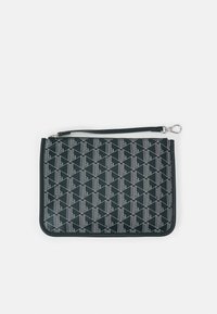 Pochette noire à fermeture éclair avec motif géométrique blanc et bracelet pour poignet avec fermoir argenté.