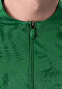 Giacca verde con cerniera e un motivo in maglia testurizzata. Presenta una cerniera visibile con una linguetta verde. Vista ravvicinata della zona del colletto.