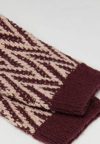 Gebreide vingerloze handschoenen met een bordeauxrode en beige zigzagpatroon, met een zachte textuur en contrasterende geribbelde boorden in effen bordeaux.
