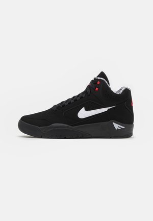Sneaker haute noire en suede, avec un swoosh Nike blanc, des accents rouges, des détails perforés et une semelle en caoutchouc texturée.