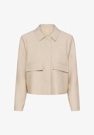 Cropped beige jacket with a collared neckline, two chest pockets, and long sleeves, made from a smooth fabric with a soft texture.