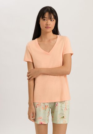 T-shirt a V con scollo a pesco in tessuto morbido, abbinata a pantaloni corti menta con motivi floreali in rosa e giallo. Maniche corte, vestibilità rilassata.