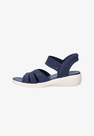 Navy blue open-toe sandal with three front straps, ankle strap, cushioned sole, and white low wedge heel.