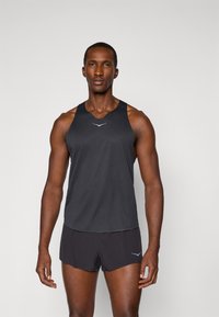Débardeur de sport noir avec un col arrondi, associé à un short noir. Présente un accent de logo bleu clair sur le devant.