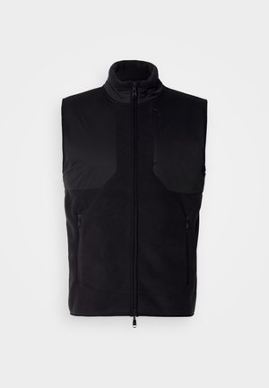 Čierna bezrukávová vesta vyrobená z jemnej textúrovanej tkaniny, s vysokým golierom, zipsom na prednej strane a dvoma bočnými vreckami.