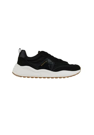 Baskets basses noires avec une semelle blanche épaisse, fermeture à lacets devant, languette au talon et marquage "SMITH X" sur la coque latérale.