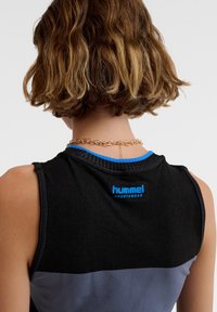 Zwart en grijs sporttanktop met blauwe accenten. Kenmerkt zich door een ronde halslijn, mouwloos ontwerp en een logo aan de achterkant. Soepele stofstructuur.