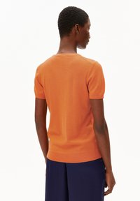 Korte mouw, aansluitend oranje gebreid shirt, gemaakt van zachte, gestructureerde stof. Kenmerkt een ronde halslijn en ribgebreide manchetten en zoom.