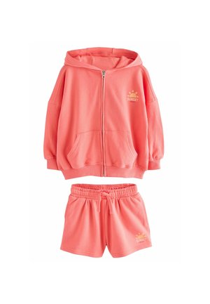 Koralfarvet zip-up hoodie med for- og lomme og "SUNSET" print, parret med matchende shorts med elastisk talje. Blødt, tekstureret stof.