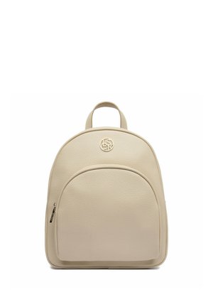 Mochila pequeña de cuero beige con bolsillo frontal con cremallera, asa superior redondeada y emblema circular con logo en el centro frontal.