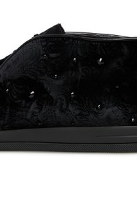 Scarpa in tessuto nero con un motivo goffrato e accentuato da strass neri. La suola è nera e texturizzata per garantire aderenza.