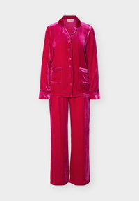 Φωτεινό ροζ βελούδινο πουκάμισο πιτζάμα με μακριά μανίκια και κουμπιά, με δύο τσέπες μπροστά και αντίστοιχο παντελόνι πιτζάμα σε φαρδιά γραμμή.