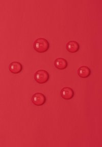 Czerwone tło z kilkoma błyszczącymi kroplami czerwonej cieczy rozrzuconymi w nieregularnym wzorze. Powierzchnia jest gładka o matowej teksturze.