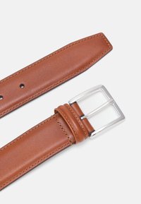 Cinturón de cuero marrón con textura suave, cinco agujeros ajustables y hebilla metálica rectangular plateada. Bordes cosidos y diseño de extremo en punta.