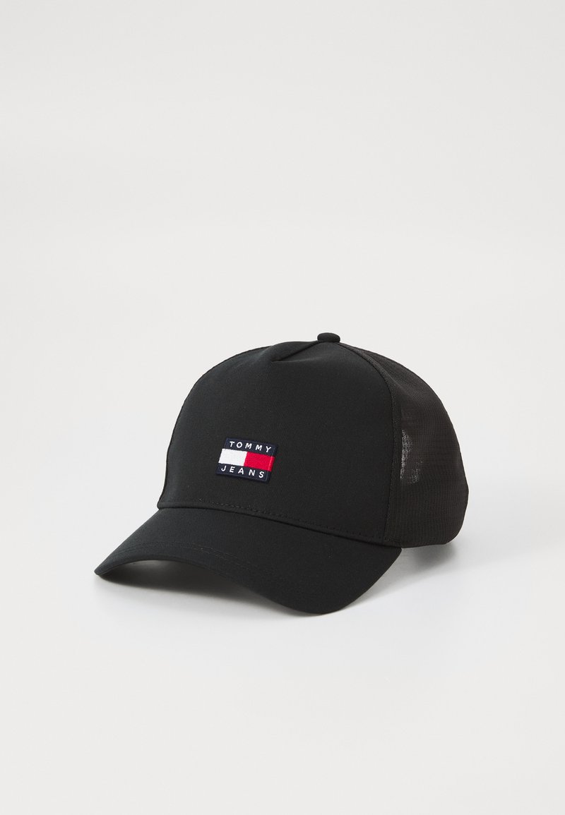 Juodas beisbolo kepurė su išlenktu kraštu, su daugiakampiu siuvinėtu logotipo pleistru, ant kurio parašyta "TOMMY JEANS". Tinklinės šoninės dalys vėdinimui.