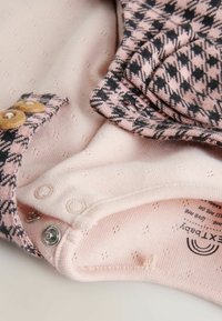 Body neonato multicolore con una base rosa caratterizzata da un motivo testurizzato e un design a houndstooth in grigio scuro e rosa. Chiusure a scatto.