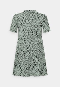 Grön mönstrad klänning med korta ärmar, rund halsringning och en svängd kjol med ett svart abstrakt mönster genom hela.