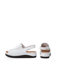 Weiße Slingback-Sandalen mit offenem Zehenbereich, gepolstertem Fußbett und elastischen Seitenpanels, die ein elegantes, minimalistisches Design präsentieren.