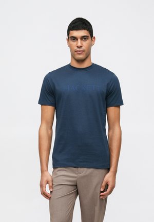 Tricou din bumbac bleumarin, cu mâneci scurte, având un logo "HACKETT" ușor ridicat, de culoare albastru închis, pe piept.