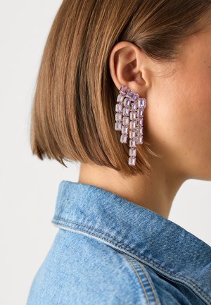 Purple beaded earrings feature rectangular beads cascading in a linear design. Made from translucent material, they showcase a light, reflective texture.