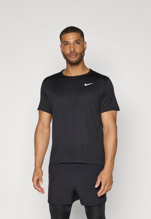 Camiseta atlética de manga corta negra de Nike con cuello redondo, tejido texturizado y un logo blanco en el lado izquierdo del pecho.