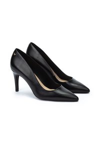 Zapatos de tacón alto de piel negra con punta afilada y un diseño elegante. Presentan un pequeño y distintivo logo en el tacón. Textura suave.