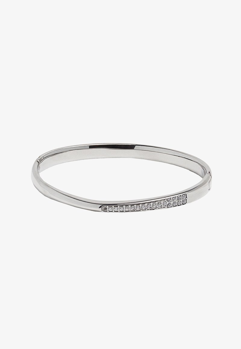 Srebrna bransoletka w formie bangle o gładkim, zakrzywionym wzorze, z rzędem osadzonych przezroczystych kryształów po jednej stronie. Gładka, metaliczna tekstura.