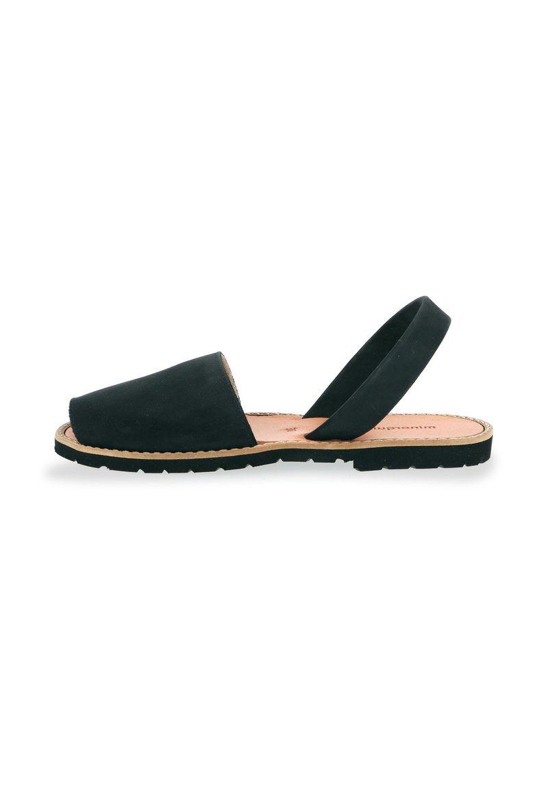 Black suede slingback sandals with a low profile, round toe, and rubber sole. Minimalist design features a smooth texture and simple silhouette.