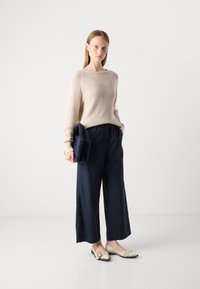 Béžový pletený svetr, námořnické široké kalhoty, krémové baleríny s černými akcenty a malá námořnická taška s texturou. Jednoduchý a moderní design.