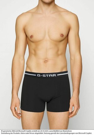 Black boxer briefs with a wide gray elastic waistband featuring "G-STAR" branding. The fabric has a smooth texture and close-fitting design.