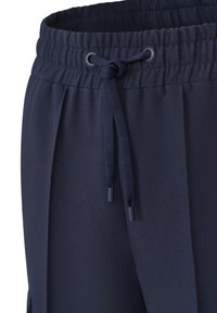 Marineblaue Sportshorts mit elastischem Bund, ausgestattet mit einem Kordelzug und glatter Stofftextur. Seitentaschen sind sichtbar.