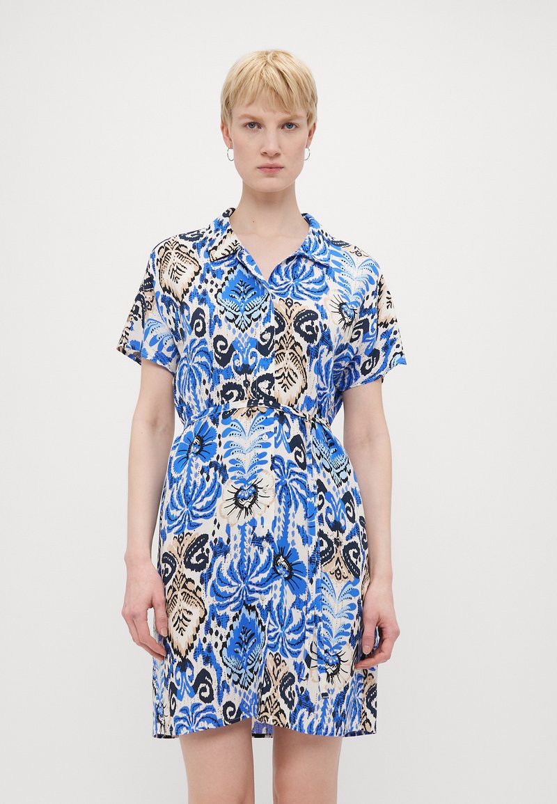 Vestido de manga curta com um padrão floral em azul, preto e bege, com gola e cintura ajustada, feito de um tecido leve.