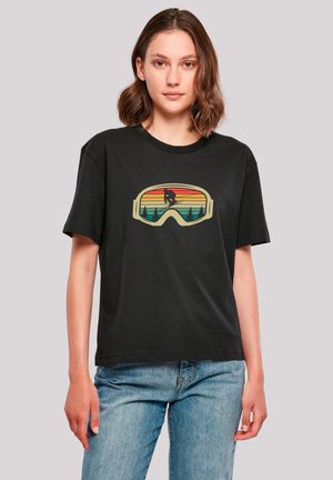 Black short-sleeve t-shirt with a graphic of ski goggles featuring a sunset and silhouette of a skier, made from soft textile material.