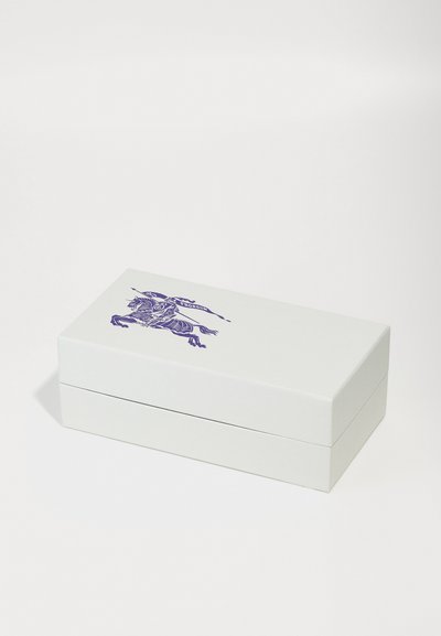Cutie albă rectangulară cu un capac plat, având un design purpuriu al unui călăreț pe partea de sus. Textură netedă, design minimalist.