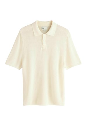 Polo majica s kratkimi rokavi v kremni barvi, izdelana iz teksturirane pletene tkanine. Ima klasičen ovratnik in zapiranje z gumbi na tri.