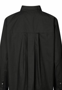 Sort skjorte med rygfold, knap- og skjortekrave samt lange ærmer. Materialet synes glat med en let glans.