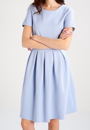 Lichtblauwe jurk met korte mouwen van een gladde stof. Beschikt over een ronde halslijn en een geplooide rok. Eenvoudig ontwerp met een nauwsluitend lijfje.