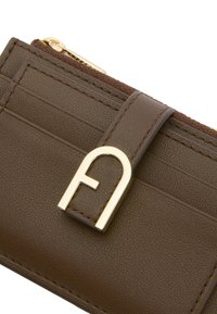 Portefeuille en cuir marron avec des détails en métal doré, doté d'une fermeture à l'avant et de plusieurs emplacements pour cartes, surface texturée et poche zippée.