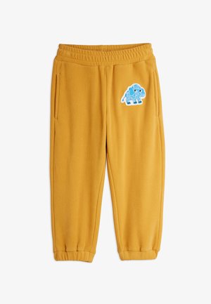 Horčicové fleecové nohavice s elastickým pásom a manžetami, s modrou karikatúrou mamuta našitou na hornej ľavej nohe.