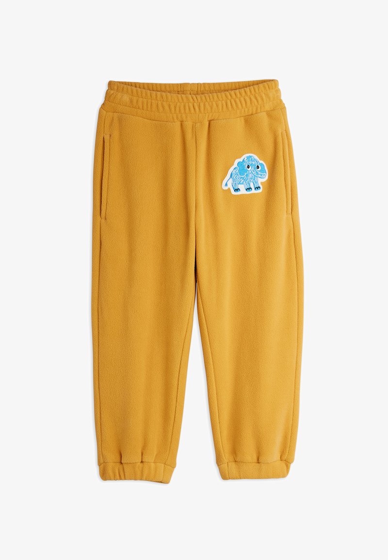Senfgelbe Fleece-Hose mit elastischem Bund und Bündchen, ausgestattet mit einem blauen Cartoon-Mammut-Patch am oberen linken Bein.
