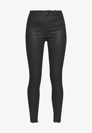 Zwarte high waist skinny broek met riemlussen en vooraan sluiting, gemaakt van een glad, licht glanzend materiaal.