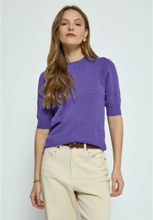Pull en maille violet à manches courtes avec un motif texturé, col rond et tissu léger, associé à un pantalon beige et une ceinture tressée.