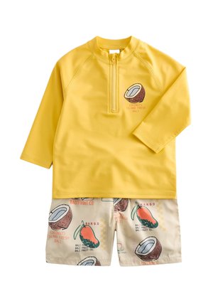 Maglietta da nuoto gialla a maniche lunghe con cerniera frontale e pantaloncini da nuoto beige con stampe di frutta cocco e mango e testo.