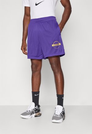 Purple mesh basketball shorts featuring a "LAKERS" logo in yellow, elastic waistband, and side pockets, paired with black athletic socks and shoes.