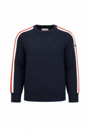 Maglione blu navy con collo rotondo, righe rosse e bianche lungo le maniche e una piccola toppa con logo sulla parte superiore del braccio.