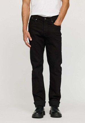 Jeans en denim noir avec une coupe droite, cinq poches et ourlets retroussés. Présente une fermeture à bouton et des garnitures en métal, portés avec un T-shirt blanc.