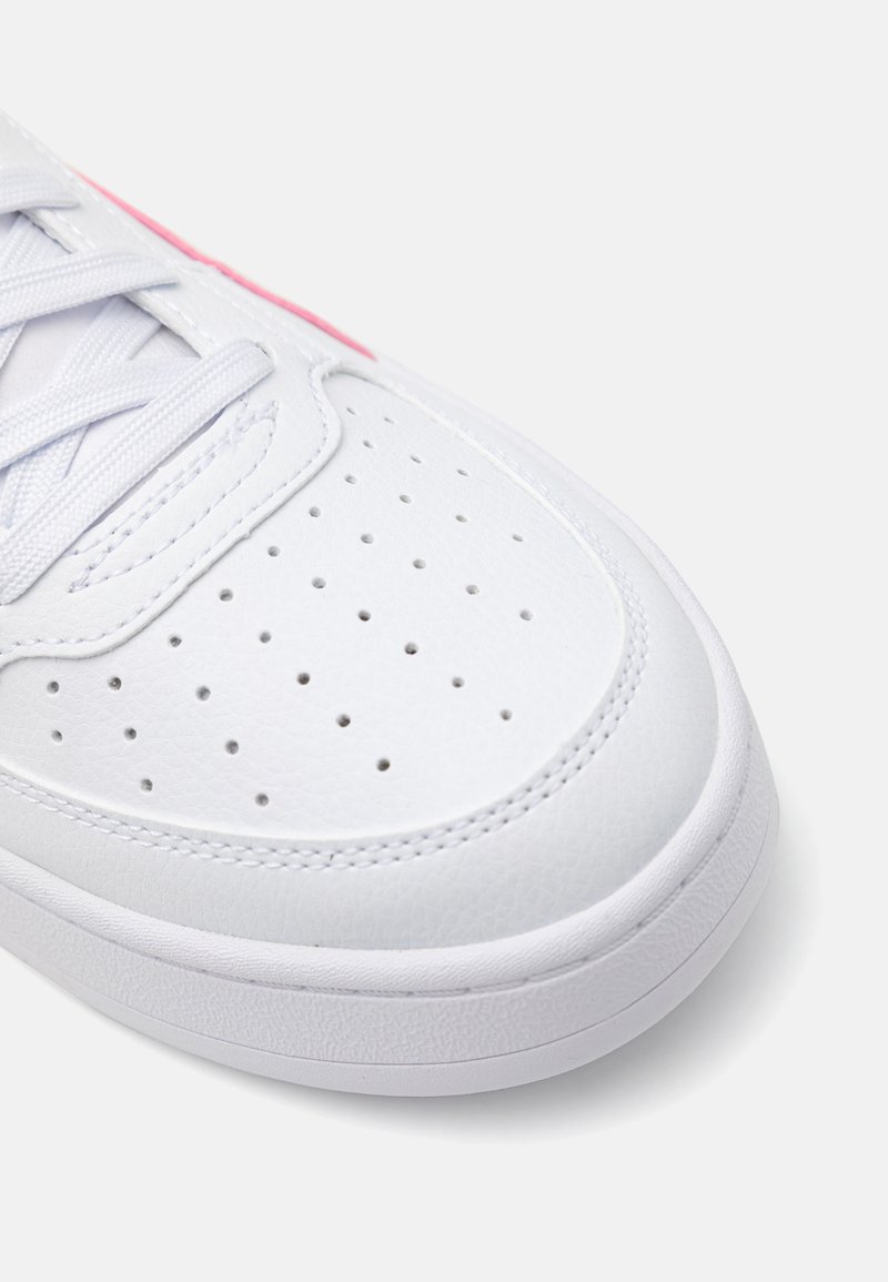 Sneaker bianca con superiore in pelle sintetica, design perforato per traspirabilità, chiusura con lacci piatti e suola in gomma testurizzata.