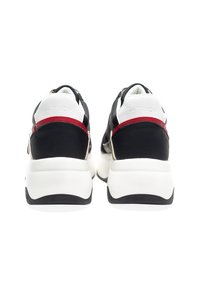 Black and white athletic sneakers with textured fabric and shiny accents. Features a cushioned sole and prominent branded heel detail.