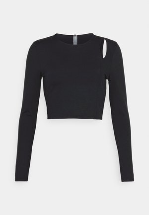 Top corto negro de manga larga con cuello redondo y un detalle cortado en el hombro izquierdo. Elaborado en una tela suave y elástica.