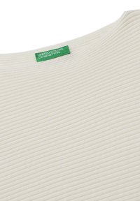 Prążkowany kremowy top z okrągłym dekoltem. Posiada zieloną metkę marki "United Colors of Benetton" w okolicy kołnierza.